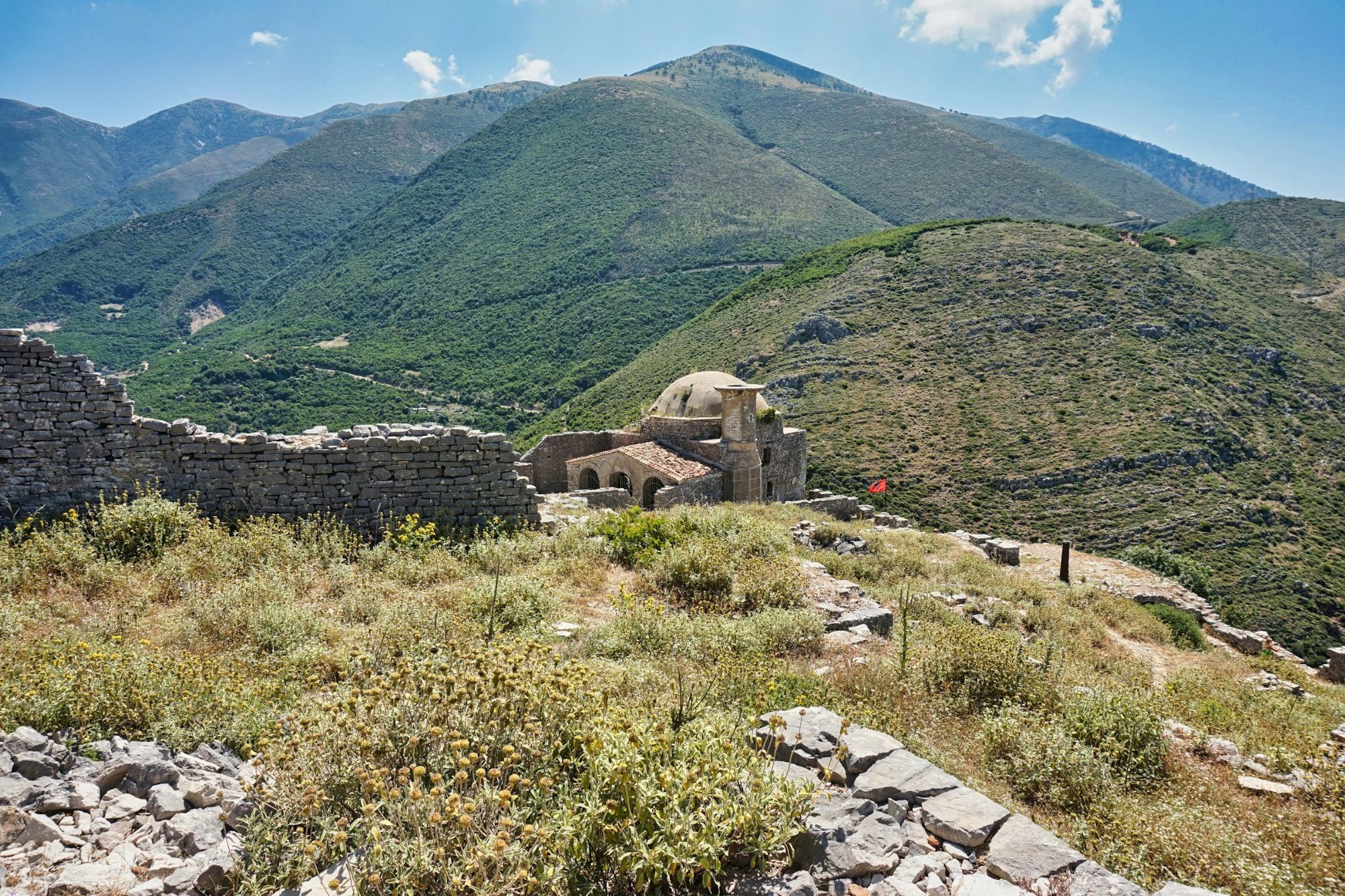 Walls and mosque of Borsh castle with the mountains behind